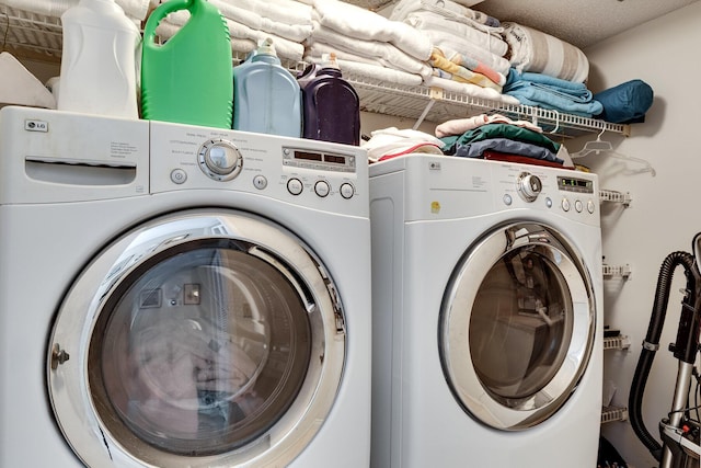 clothes washing area with washer and clothes dryer and laundry area