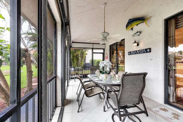 sunroom featuring outdoor dining area and a ceiling fan