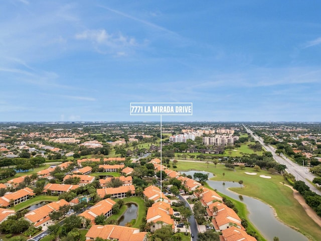 drone / aerial view featuring a water view, golf course view, and a residential view