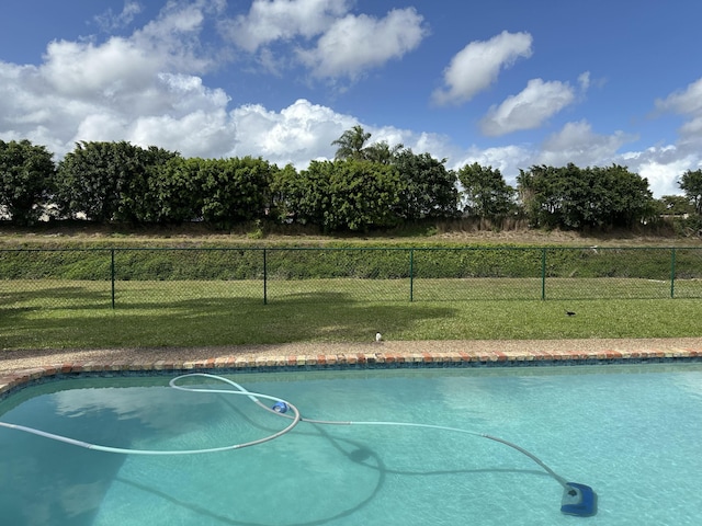 view of swimming pool with a lawn, a fenced in pool, and fence