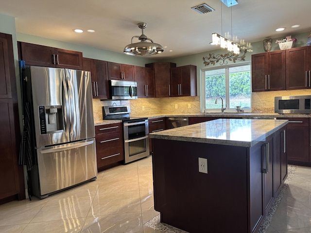 kitchen with a sink, visible vents, recessed lighting, a center island, and appliances with stainless steel finishes