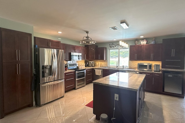 kitchen featuring visible vents, recessed lighting, backsplash, a kitchen island, and appliances with stainless steel finishes