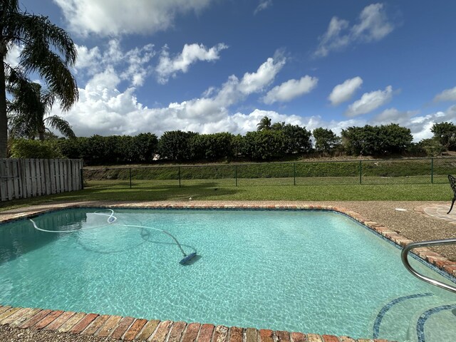 view of pool featuring fence, a fenced in pool, and a lawn