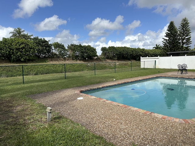 view of pool featuring a yard, fence, and a fenced in pool
