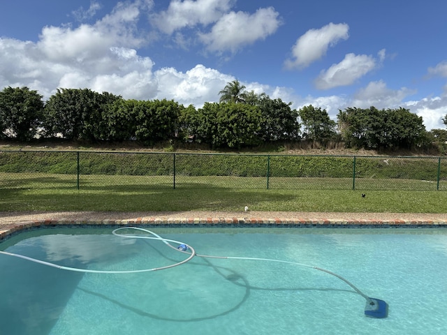 view of pool with fence, a fenced in pool, and a lawn
