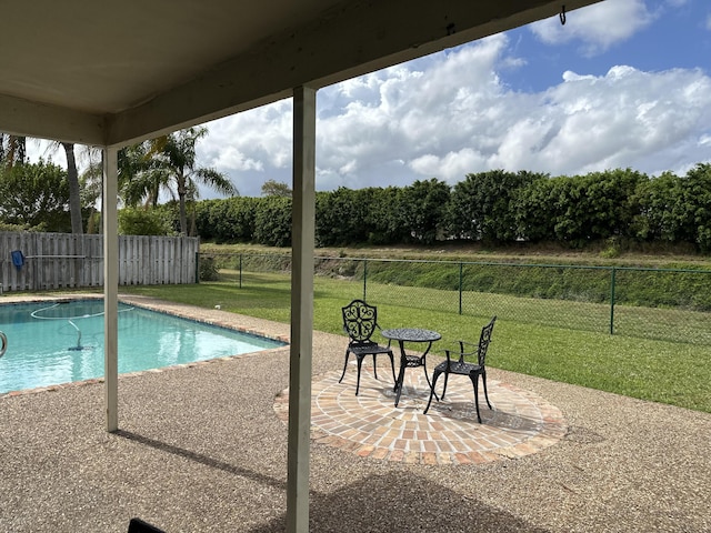 view of swimming pool featuring a yard, fence, and a patio area