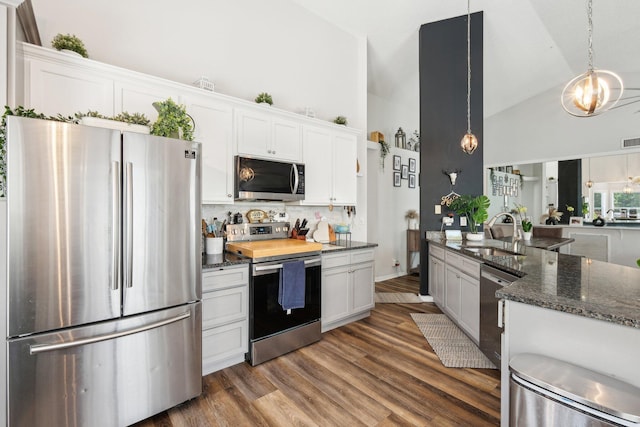 kitchen with white cabinets, a sink, high vaulted ceiling, stainless steel appliances, and backsplash