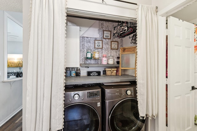 laundry area with baseboards, laundry area, washer and clothes dryer, and wood finished floors