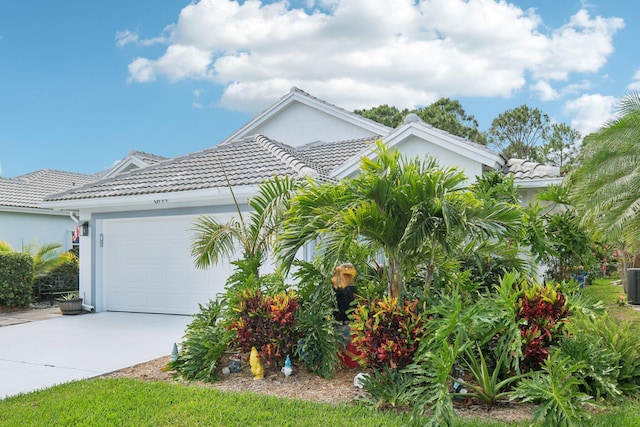 view of front of property featuring an attached garage, stucco siding, concrete driveway, and a tile roof