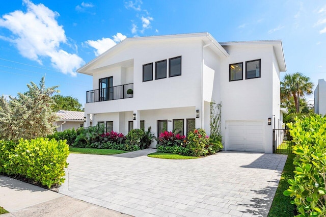 306 Plymouth Rd, West Palm Beach, FL 33405 - contemporary home featuring a garage, stucco siding, decorative driveway, and a balcony
