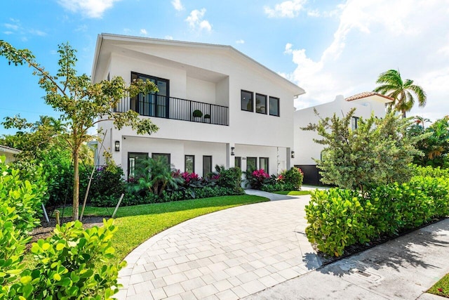 306 Plymouth Rd, West Palm Beach, FL 33405 - view of front facade with a balcony, stucco siding, and a front lawn