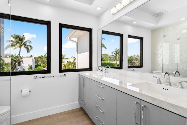 306 Plymouth Rd, West Palm Beach, FL 33405 - bathroom featuring toilet, a stall shower, a healthy amount of sunlight, and a sink