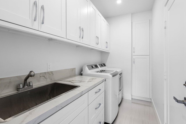 306 Plymouth Rd, West Palm Beach, FL 33405 - washroom featuring baseboards, washing machine and clothes dryer, a sink, and cabinet space