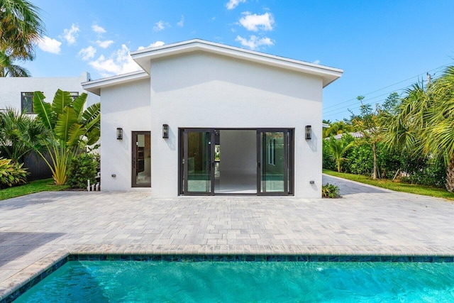 306 Plymouth Rd, West Palm Beach, FL 33405 - rear view of property featuring a patio, an outdoor pool, and stucco siding