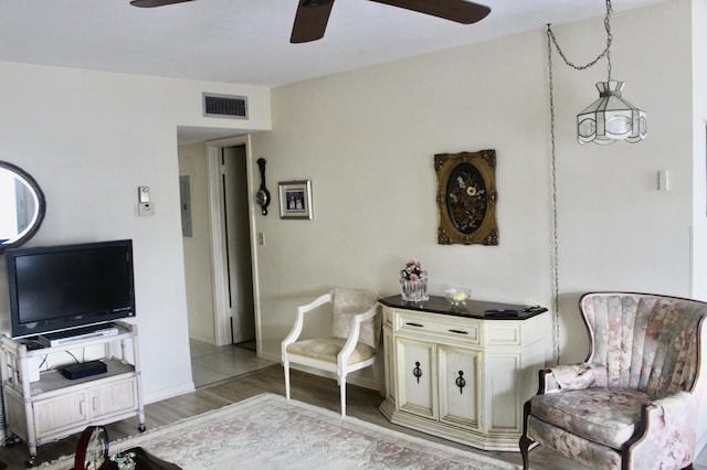interior space with visible vents, baseboards, a ceiling fan, and wood finished floors