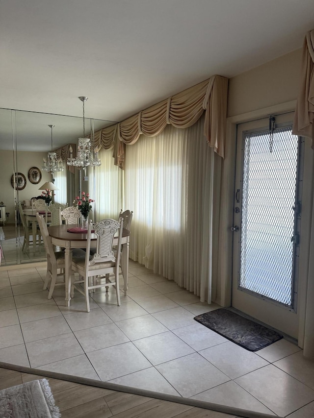 dining area with light tile patterned floors and a chandelier