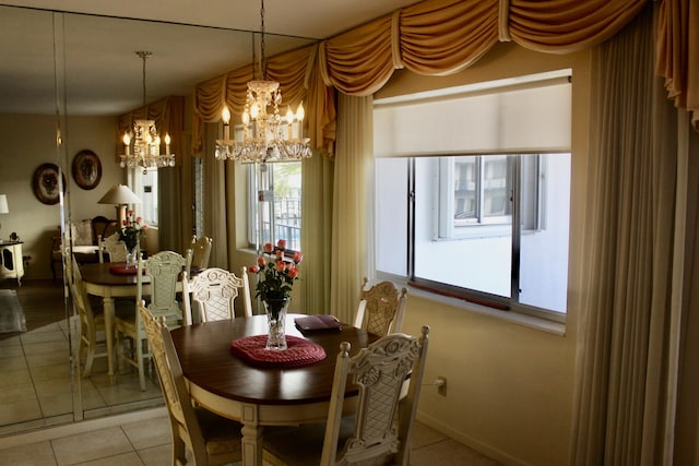 dining space with light tile patterned flooring, a notable chandelier, and baseboards