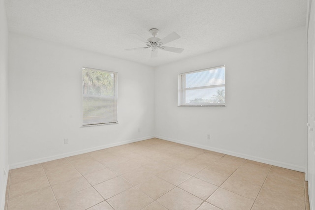 unfurnished room with baseboards, a ceiling fan, a textured ceiling, and light tile patterned floors