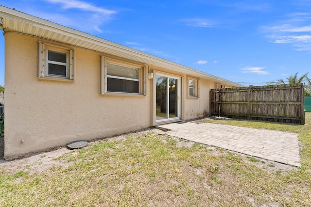 back of house featuring fence, stucco siding, and a patio area