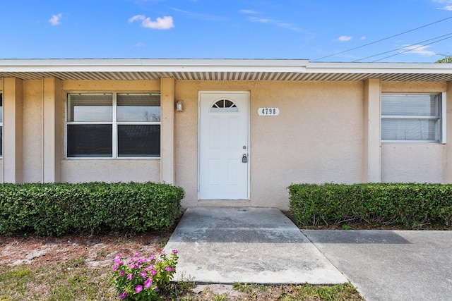view of exterior entry with stucco siding