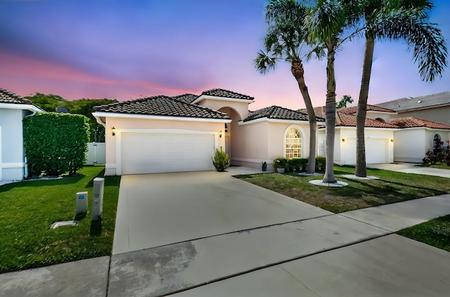 6090 Newport Village Way, Lake Worth, FL 33463 - mediterranean / spanish-style home featuring a front yard, a tiled roof, an attached garage, stucco siding, and driveway