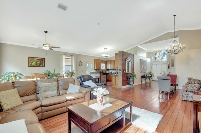6090 Newport Village Way, Lake Worth, FL 33463 - living room with light wood-style floors, ceiling fan with notable chandelier, ornamental molding, visible vents, and lofted ceiling