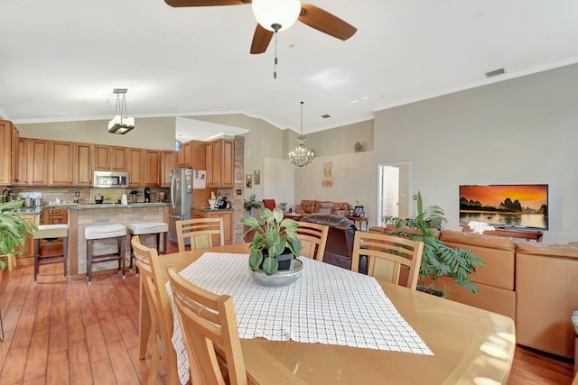 6090 Newport Village Way, Lake Worth, FL 33463 - dining area with ornamental molding, visible vents, light wood-type flooring, and ceiling fan with notable chandelier