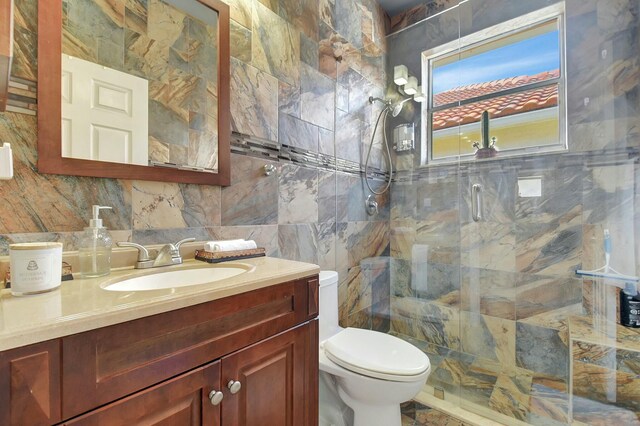 6090 Newport Village Way, Lake Worth, FL 33463 - full bath with vanity, a stall shower, toilet, decorative backsplash, and tile walls