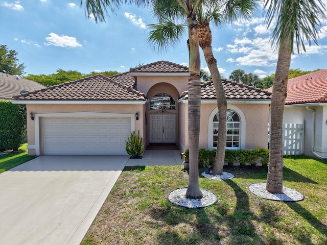 6090 Newport Village Way, Lake Worth, FL 33463 - mediterranean / spanish home with a front yard, a tiled roof, a garage, stucco siding, and driveway