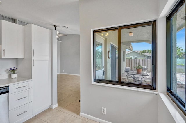 5680 Northpointe Ln, Boynton Beach, FL 33437 - kitchen with white cabinets, light tile patterned flooring, baseboards, and ceiling fan