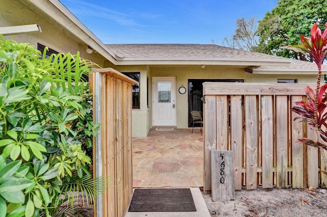 5680 Northpointe Ln, Boynton Beach, FL 33437 - entrance to property featuring fence, a shingled roof, and stucco siding
