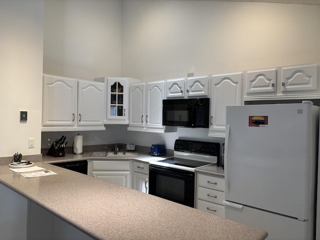 1801 S US Highway 1 Unit 12B, Jupiter, FL 33477 - kitchen with black appliances, a sink, white cabinets, glass insert cabinets, and a peninsula