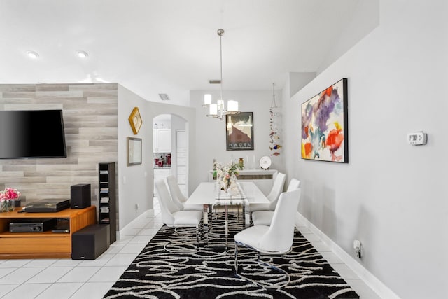 dining room featuring visible vents, light tile patterned floors, arched walkways, baseboards, and a notable chandelier