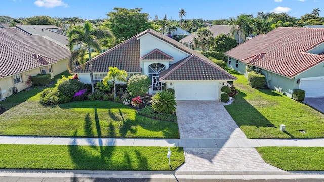 view of front facade with a residential view, stucco siding, a tile roof, driveway, and a garage