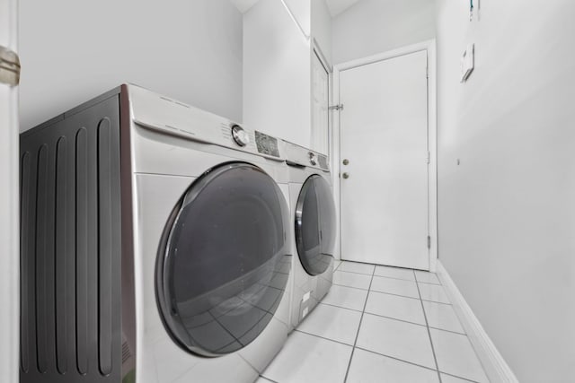 laundry room with light tile patterned flooring, independent washer and dryer, and laundry area