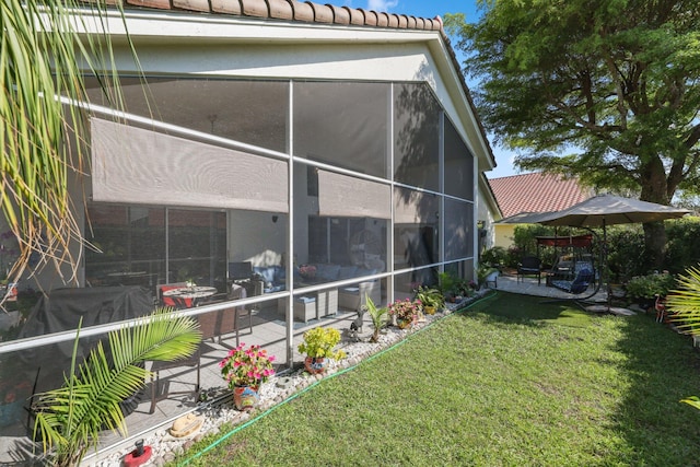 exterior space with a yard, a tile roof, a patio, and stucco siding