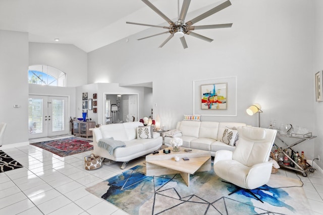 living area with french doors, baseboards, a ceiling fan, tile patterned flooring, and high vaulted ceiling