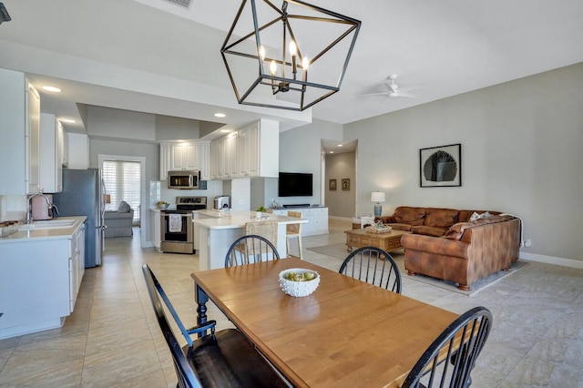 dining area with baseboards and ceiling fan with notable chandelier