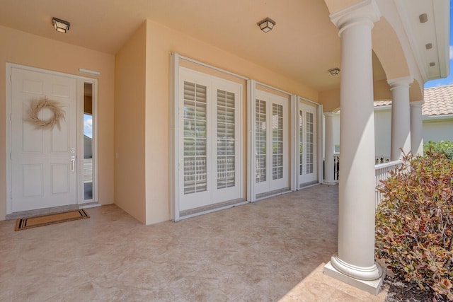 view of exterior entry featuring a patio area and stucco siding