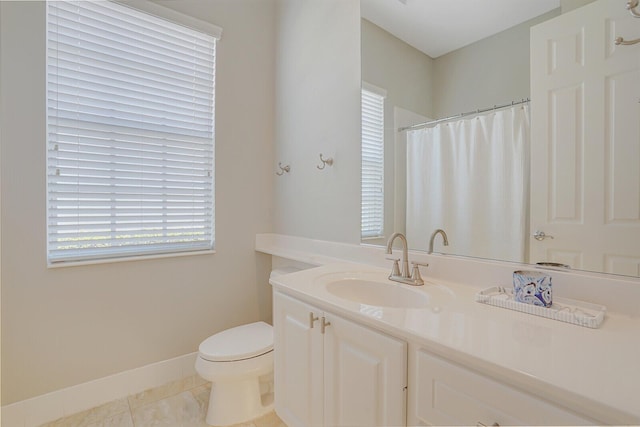 bathroom featuring curtained shower, baseboards, tile patterned floors, vanity, and toilet