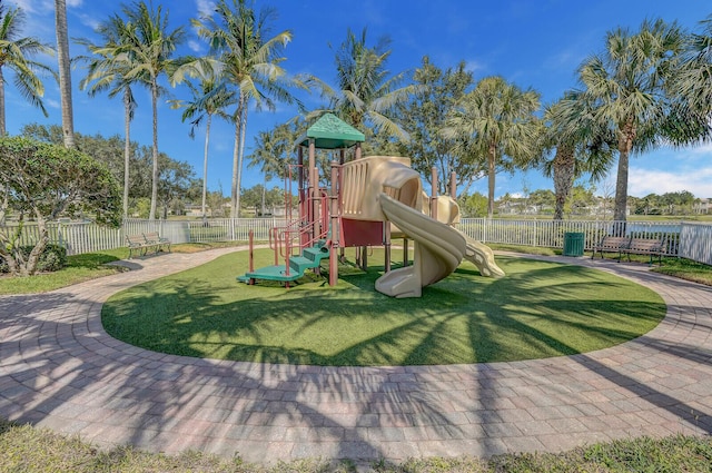 communal playground featuring a lawn and fence