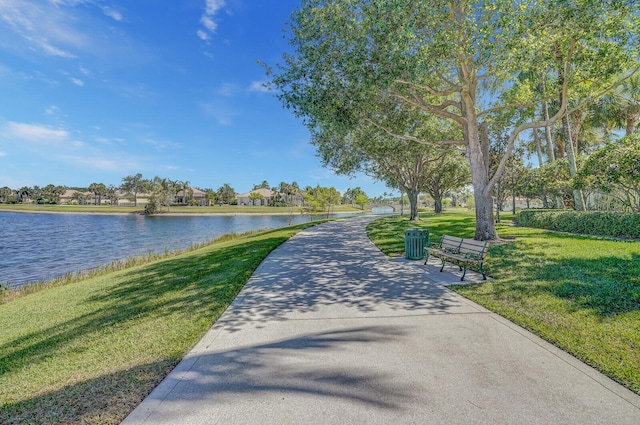 view of home's community with a lawn and a water view