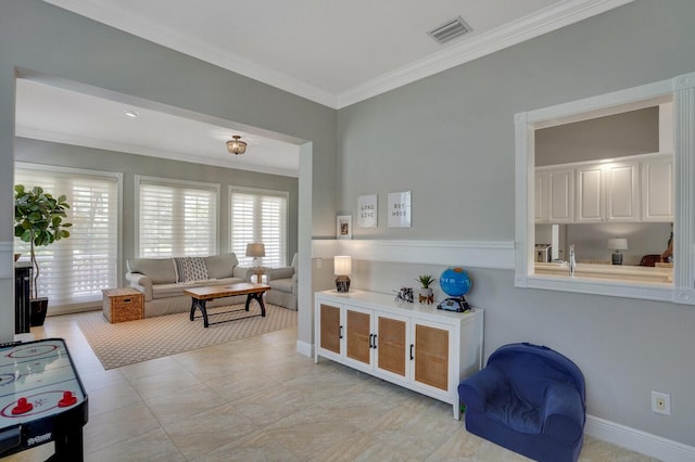 living room featuring crown molding, baseboards, and visible vents