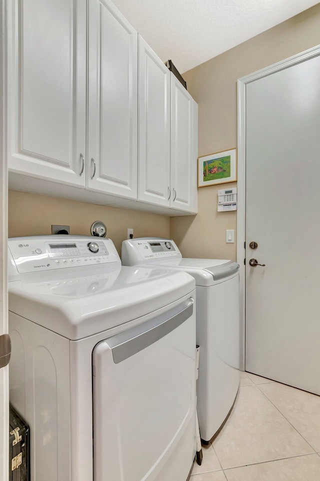 6722 Watertown Dr, Boynton Beach, FL 33437 - laundry area featuring light tile patterned floors, cabinet space, and washer and clothes dryer