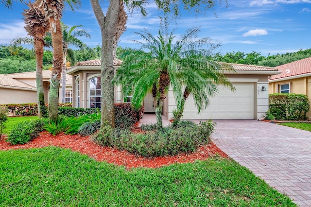 6722 Watertown Dr, Boynton Beach, FL 33437 - view of front of house with an attached garage, stucco siding, a tile roof, and decorative driveway