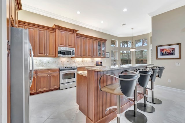 6722 Watertown Dr, Boynton Beach, FL 33437 - kitchen with backsplash, brown cabinetry, appliances with stainless steel finishes, and a kitchen breakfast bar