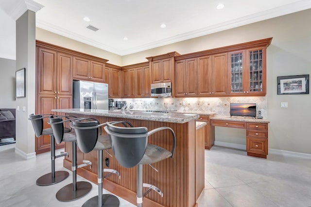 6722 Watertown Dr, Boynton Beach, FL 33437 - kitchen featuring visible vents, brown cabinetry, appliances with stainless steel finishes, and a breakfast bar
