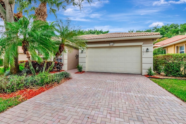 6722 Watertown Dr, Boynton Beach, FL 33437 - view of front facade with an attached garage, a tiled roof, stucco siding, and decorative driveway