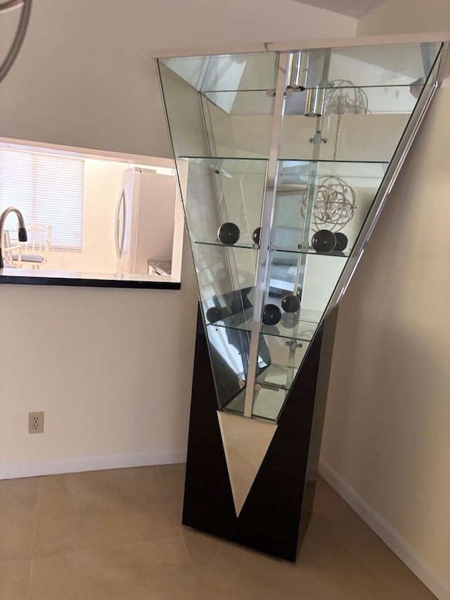 details featuring freestanding refrigerator, baseboards, and a sink