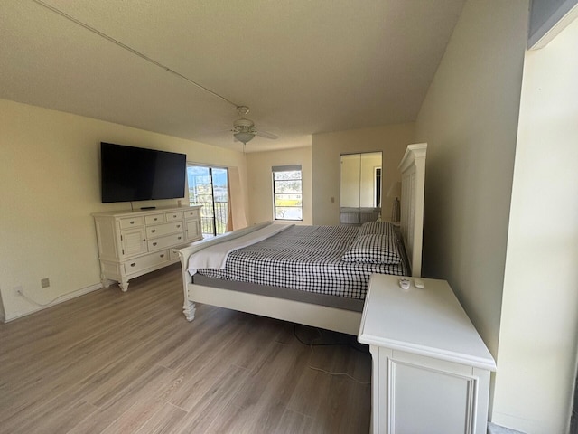 bedroom with a ceiling fan, baseboards, and light wood finished floors
